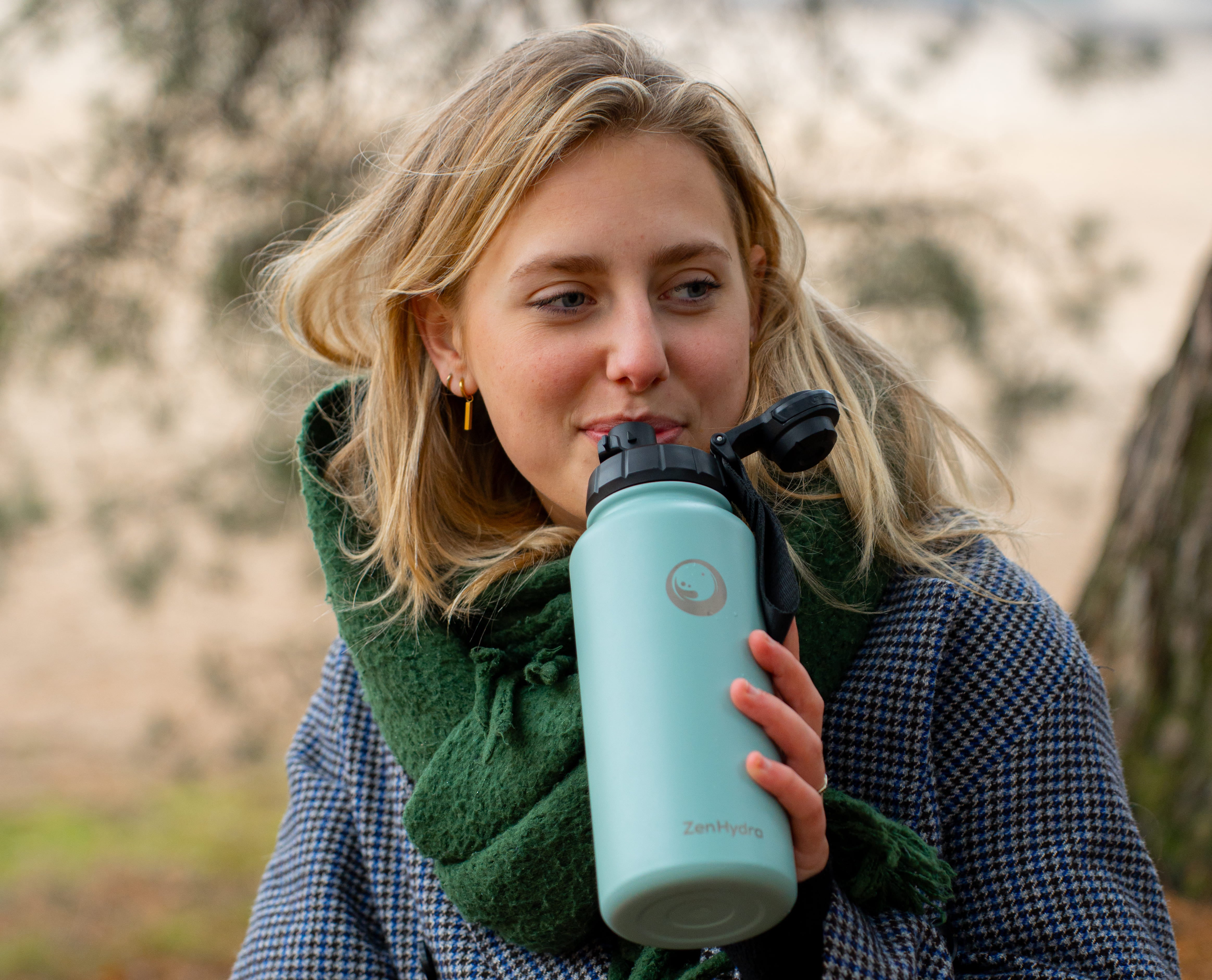 vrouw met zenhydra fles in bos