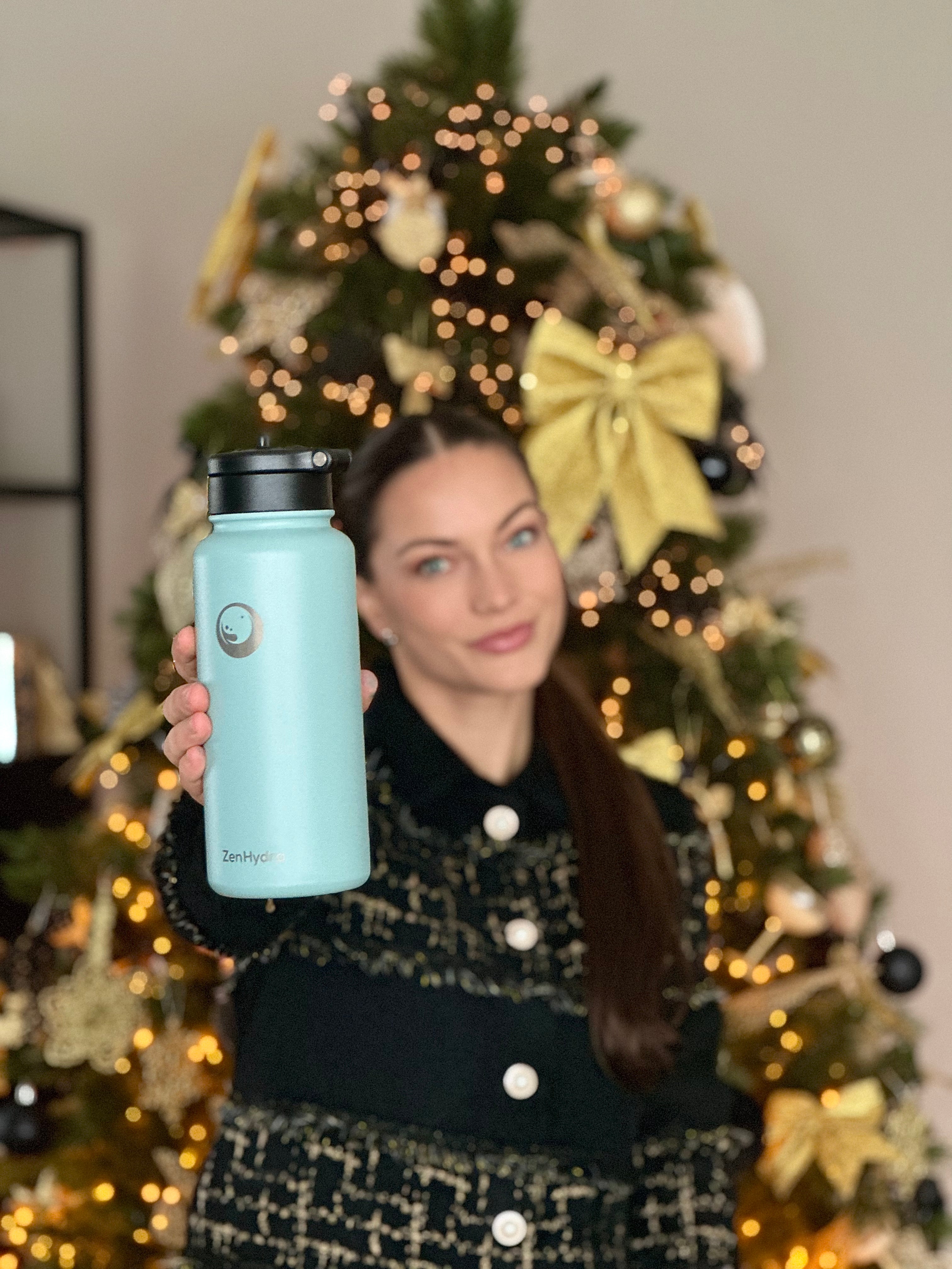 Vrouw voor kerstboom met een Zenhydra drinkfles